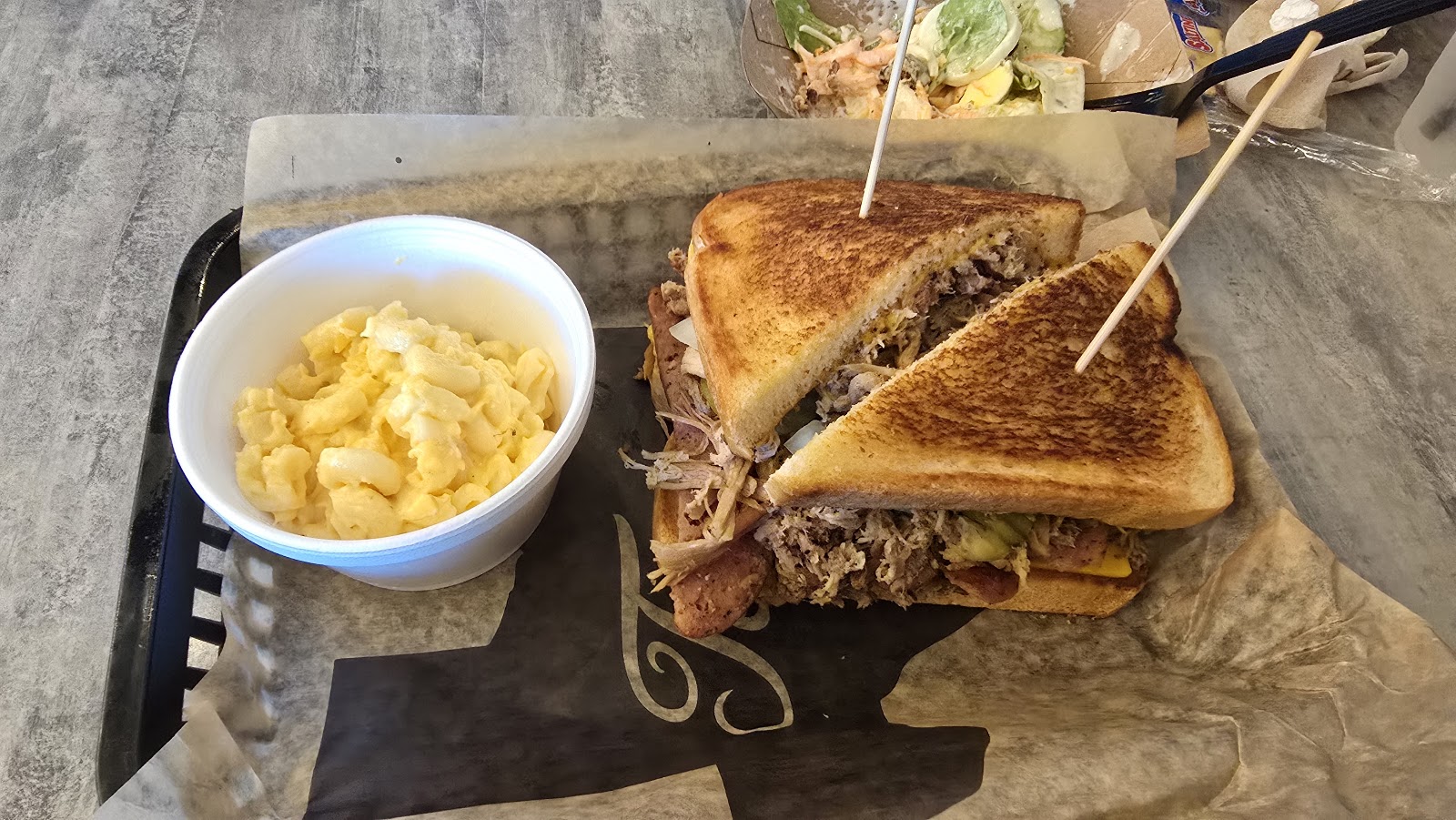Grilled sandwich served with a side of macaroni salad
