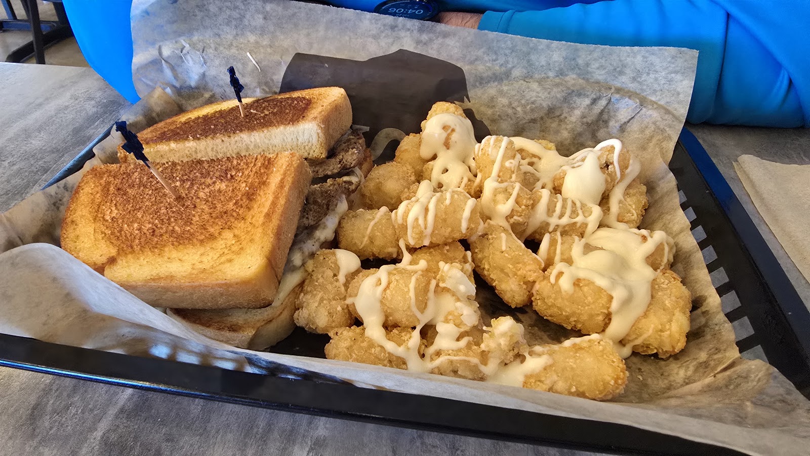 Basket of crispy onion rings and a grilled sandwich