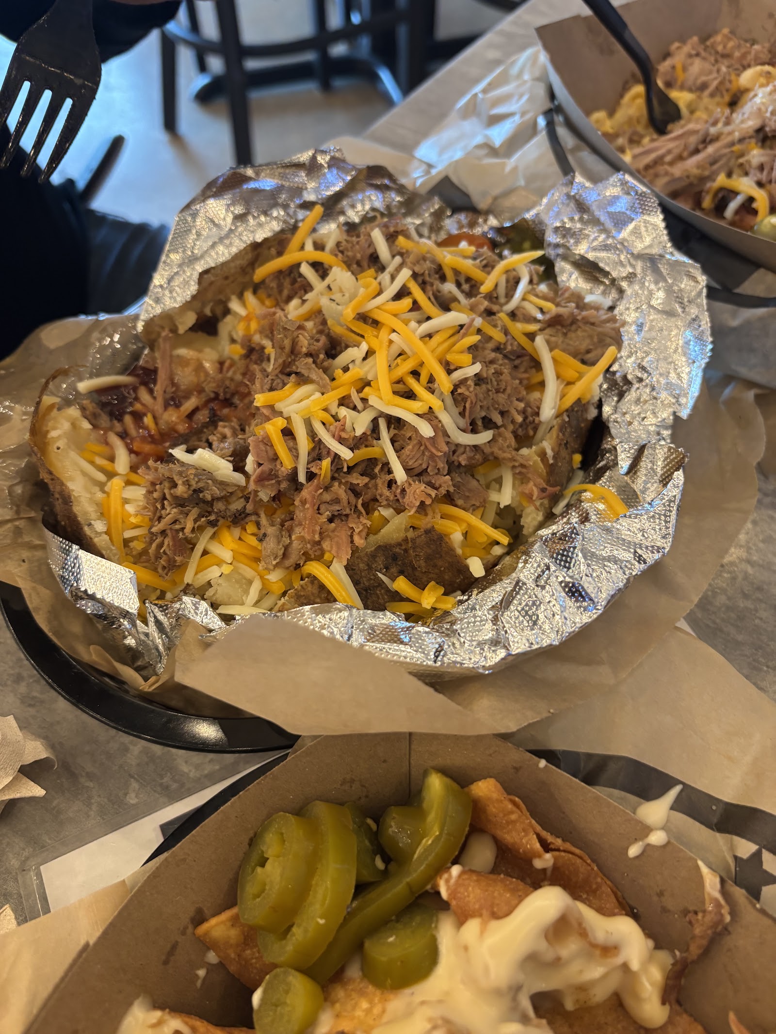 Loaded baked potato topped with pulled pork and shredded cheese