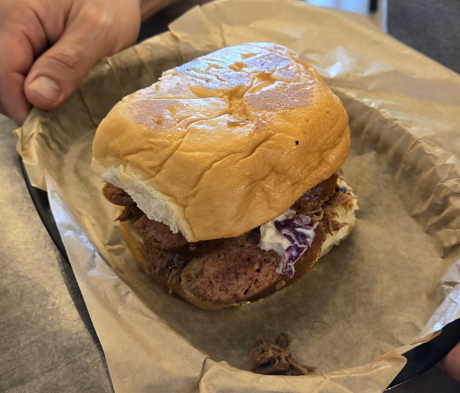 Smoked sausage sandwich topped with coleslaw