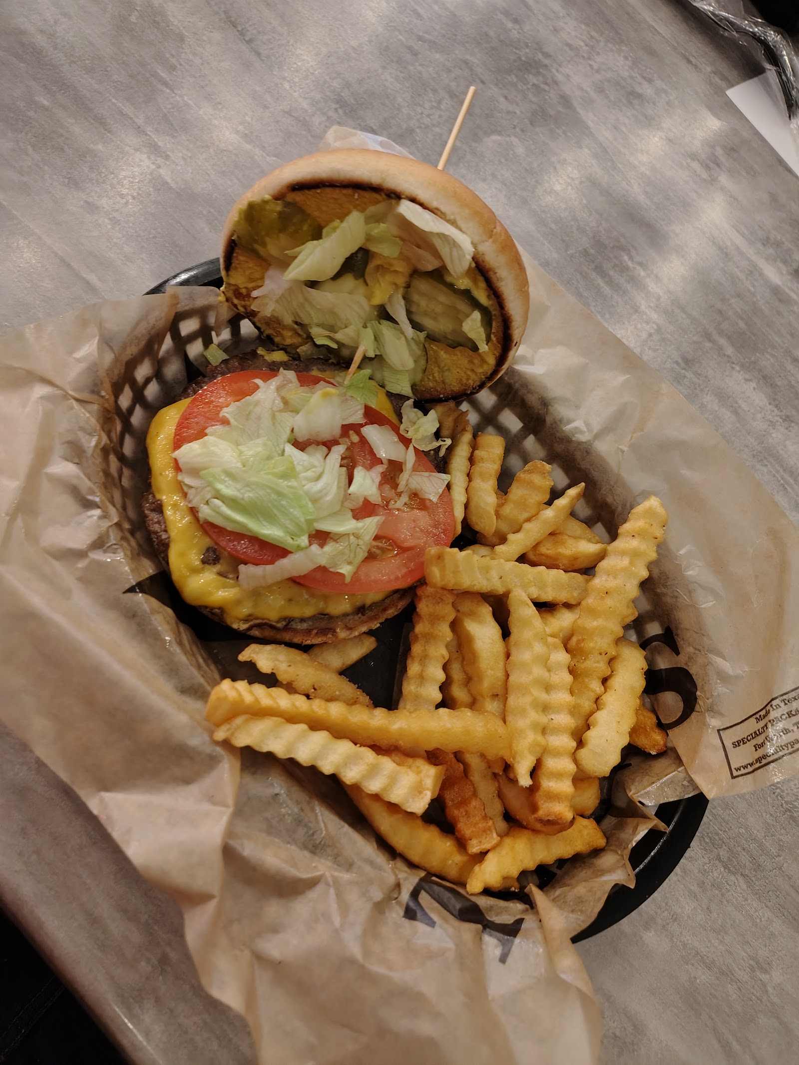 Cheeseburger with lettuce and tomato served with crinkle fries